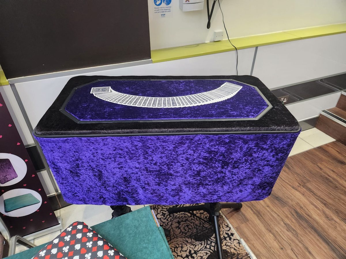 Octagonal top table, purple velvet, full deck fanned across surface